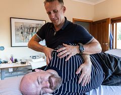 Man laying on site, being given osteopathic treatment
