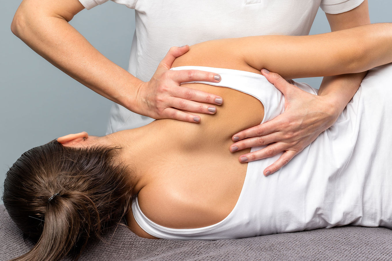 Woman laying on side getting physiotherapy for her back